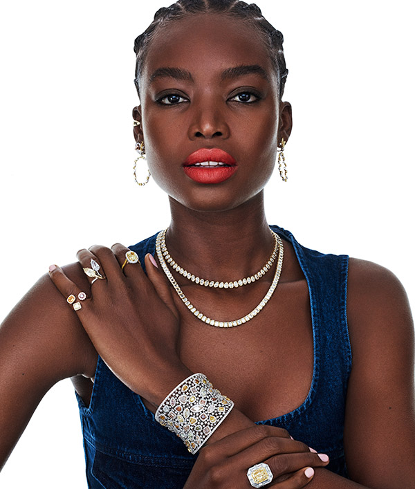 Model in denim with tennis necklaces and yellow diamond ring
