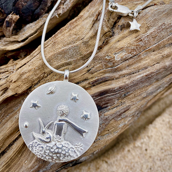 The pendant from The Little Prince collection comes on a 30 inch snake chain that can be worn long or doubled up to be worn the length of a choker.  A mini star is attached to the clasp, giving the back of the coin a special touch.