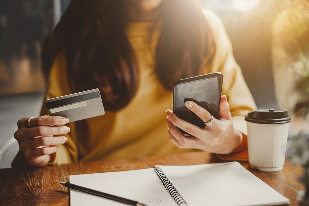 Woman holding smartphone and credit card