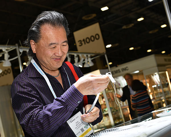 Man looking at pearls at 2022 JCK show