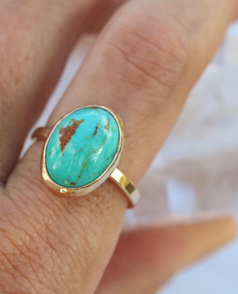 A gold ring featuring American-mined turquoise on a hand