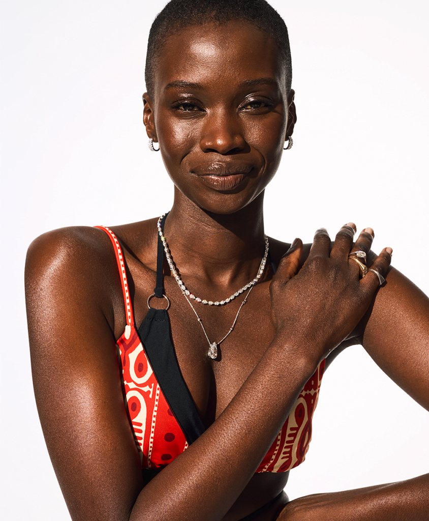 Model in diamond jewelry and orange and black bikinis