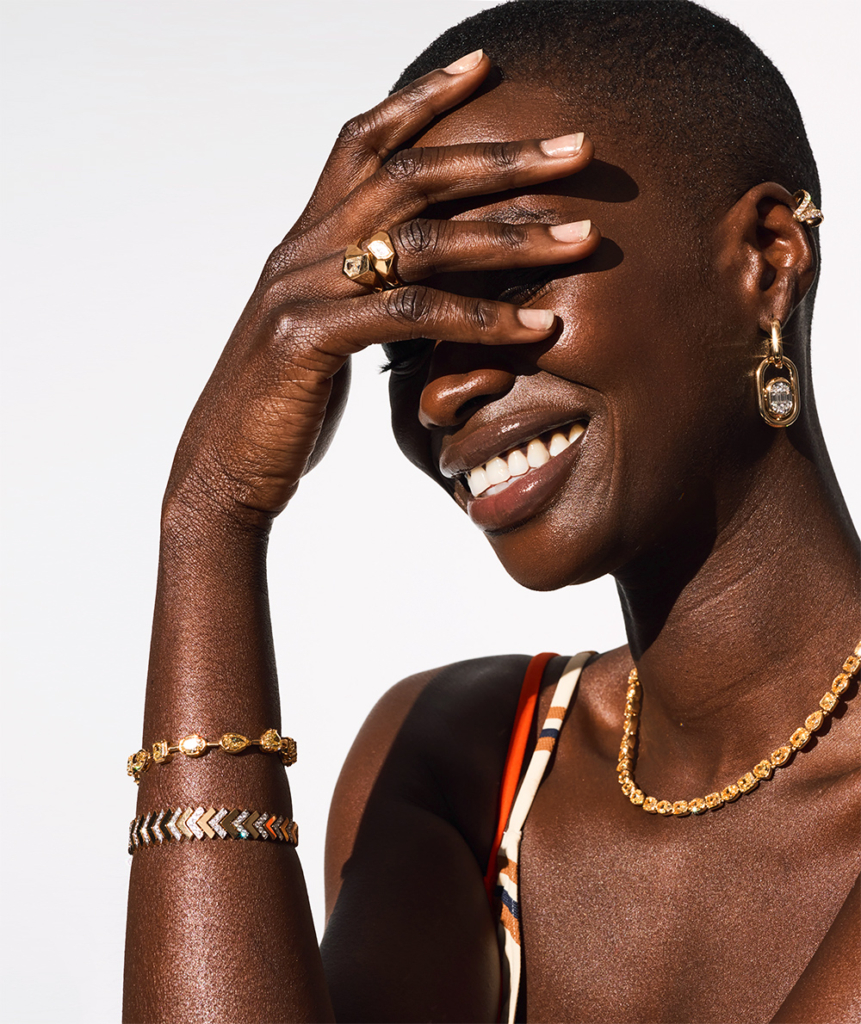 Model in diamond jewelry smiling covering her eyes
